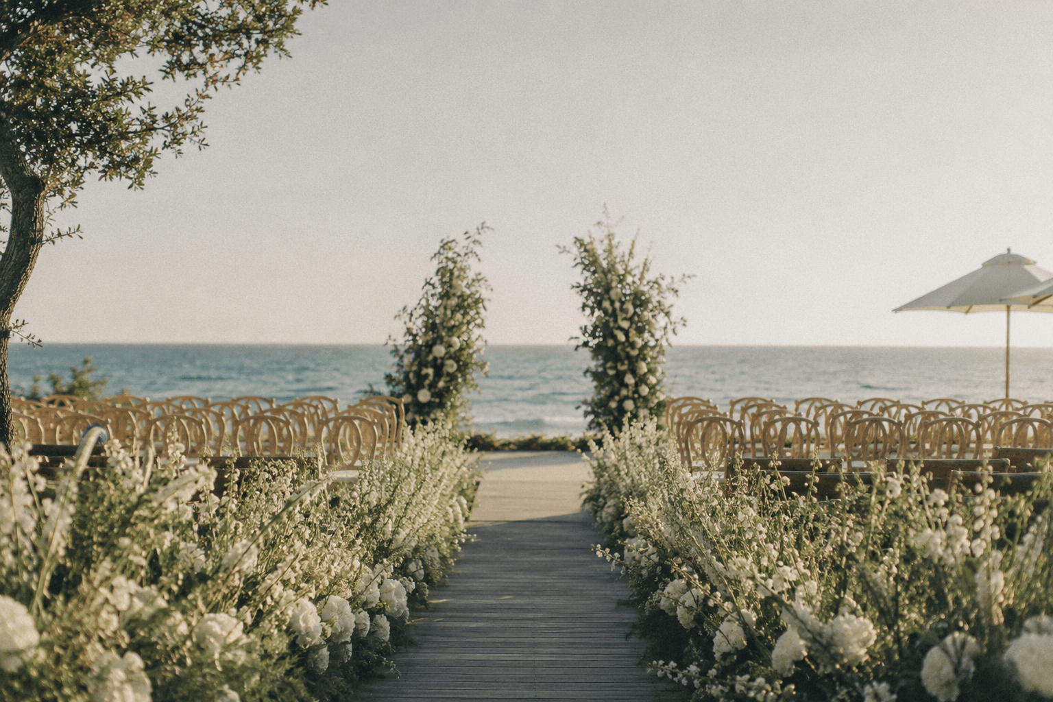 An elegant coastal wedding celebration in warm evening light.