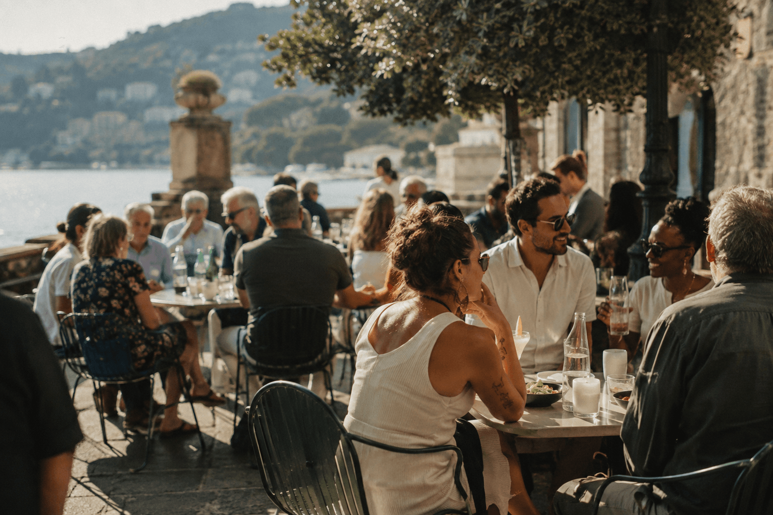 Friends of different ages socializing at a lively outdoor restaurant with a mix of alcohol-free drinks and other beverages.