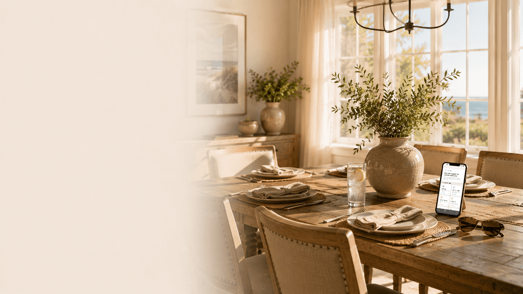A warm coastal dining room prepared for a gathering, with Nova's sobriety support for social situations displayed on a phone.