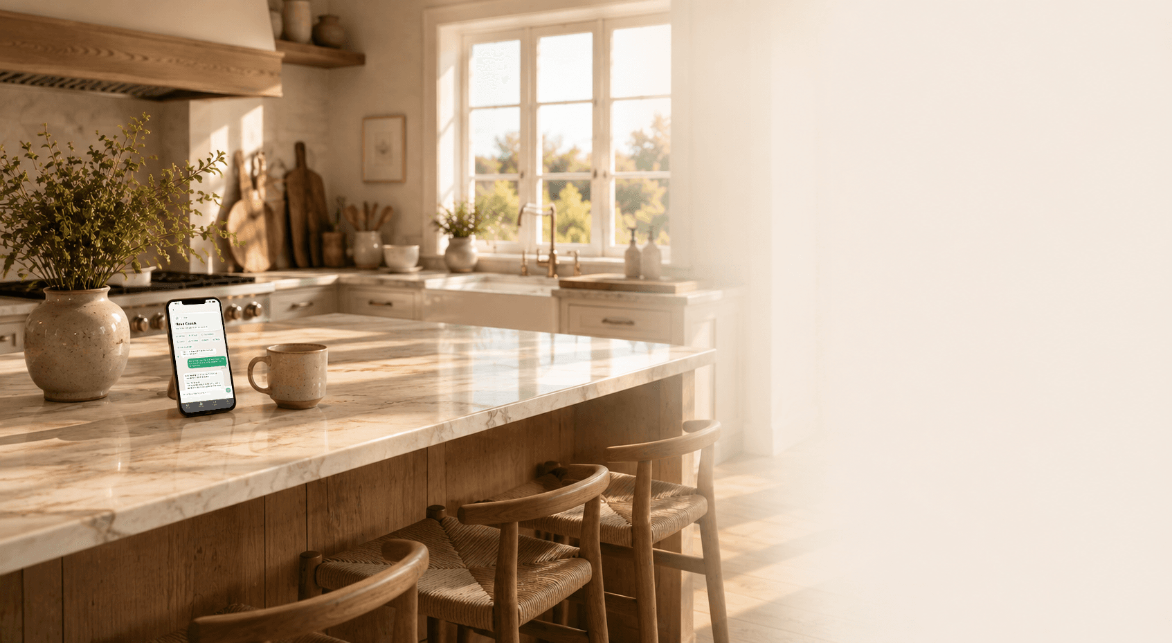 A warm coastal kitchen in morning light with Nova Coach displayed on a phone.