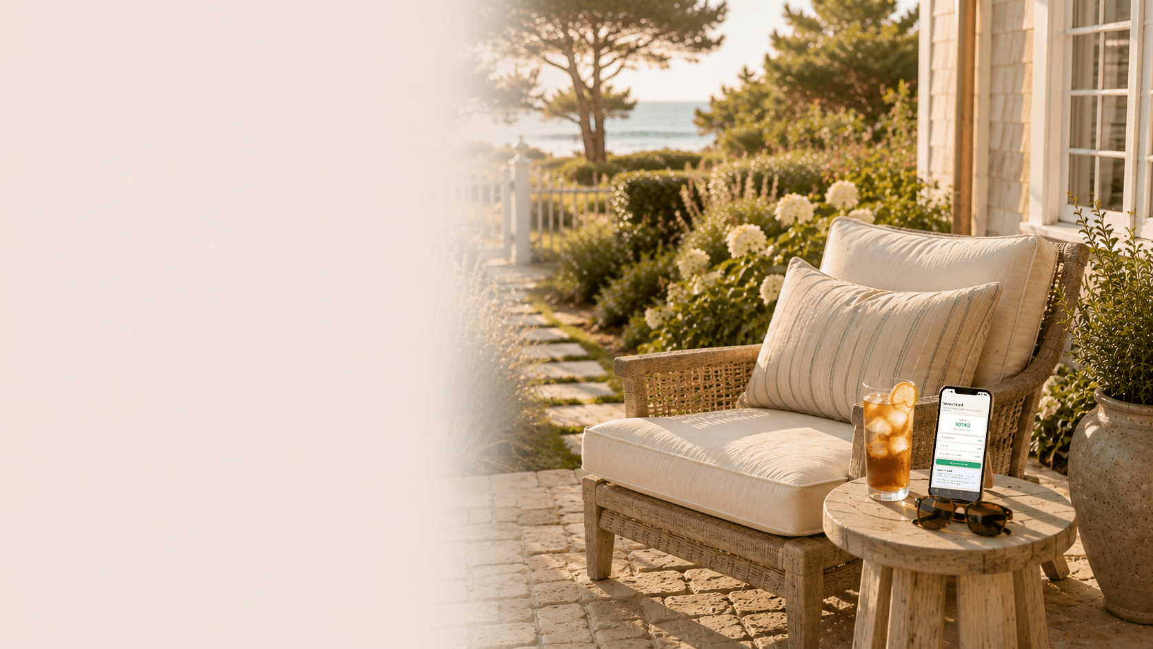 A peaceful coastal garden sitting area with Nova's money saved from quitting alcohol tracker displayed on a phone.